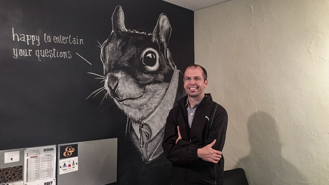 man next to squirrel drawing on wall