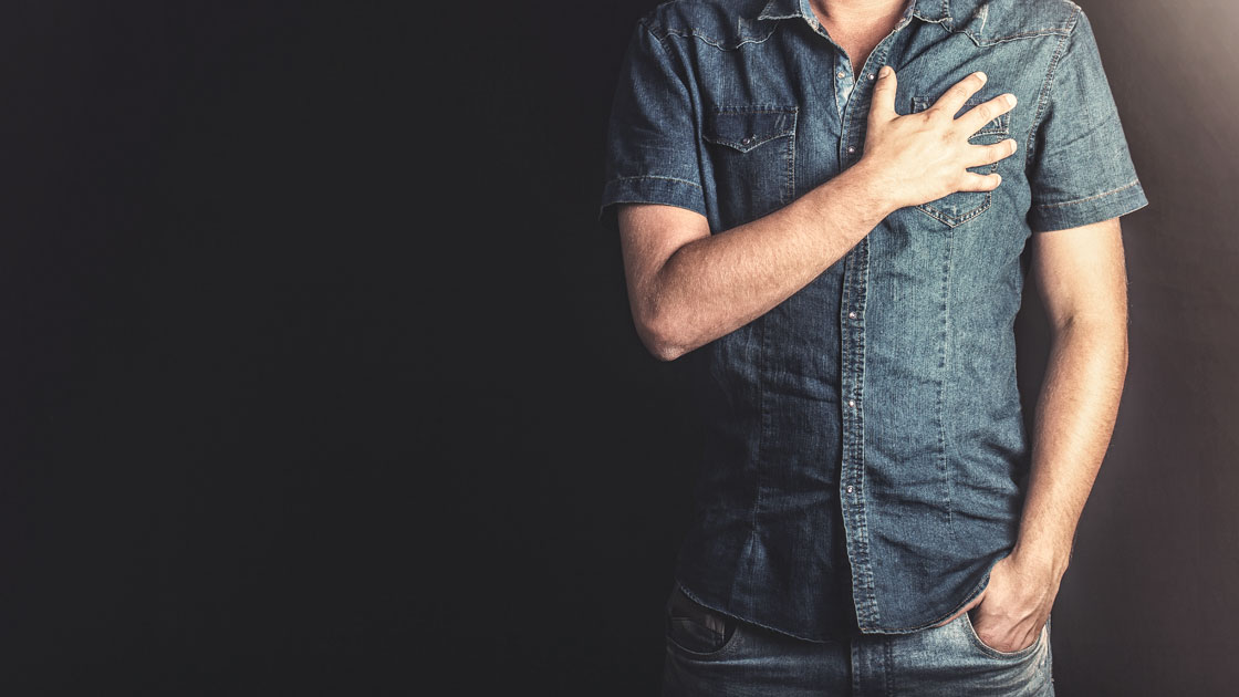 Man standing with hand over his heart