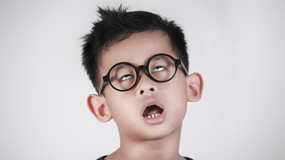 Young boy wearing funny glasses making a bored, annoyed face