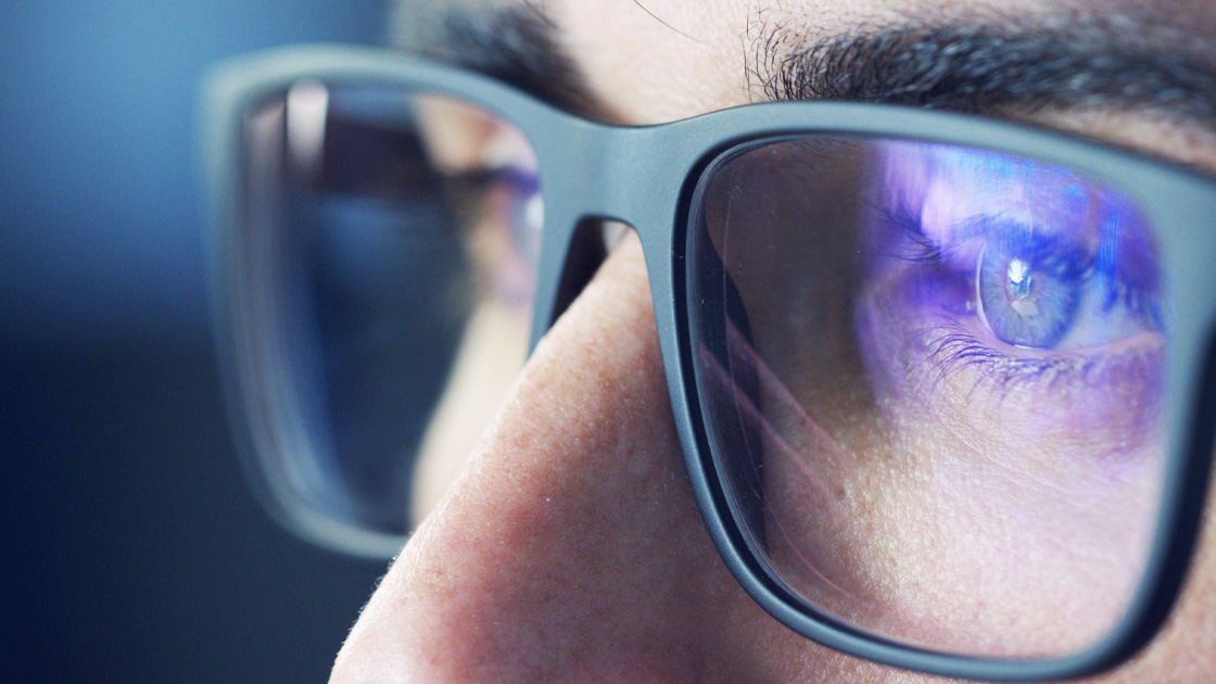 Close-up of persona wearing Art Director glasses with computer screen reflected in lenses