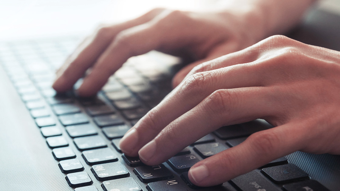 Close-up of someone typing on laptop keyboard