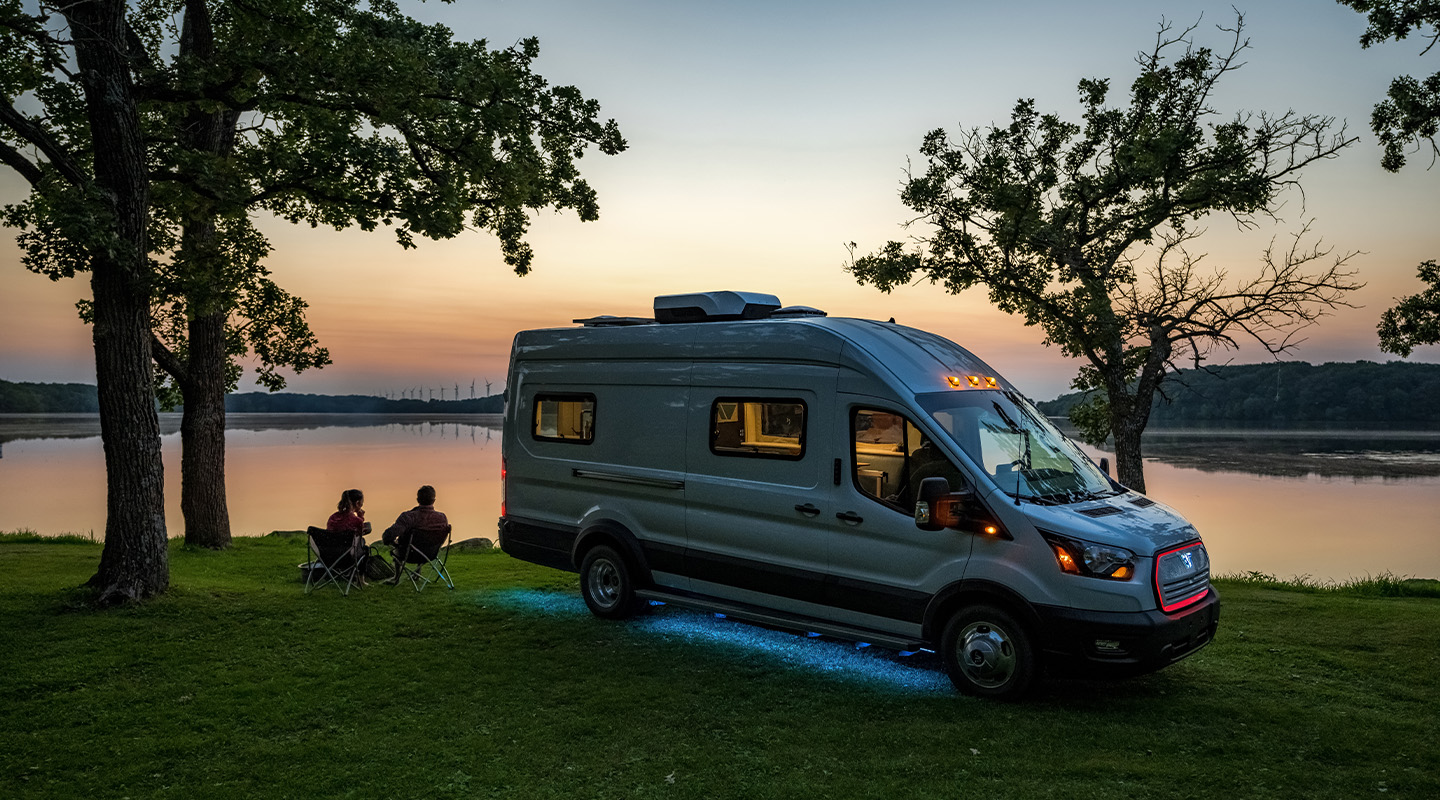 camper van parked near lake at sunset