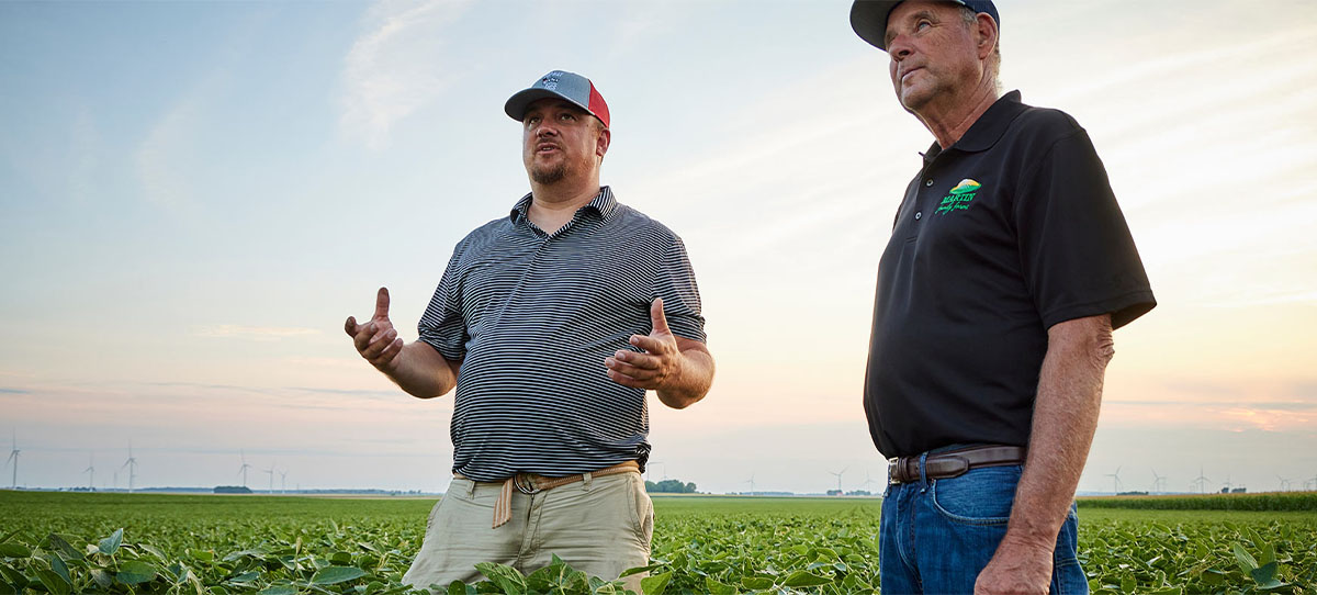 ADM representative and producer chatting in a soybean field