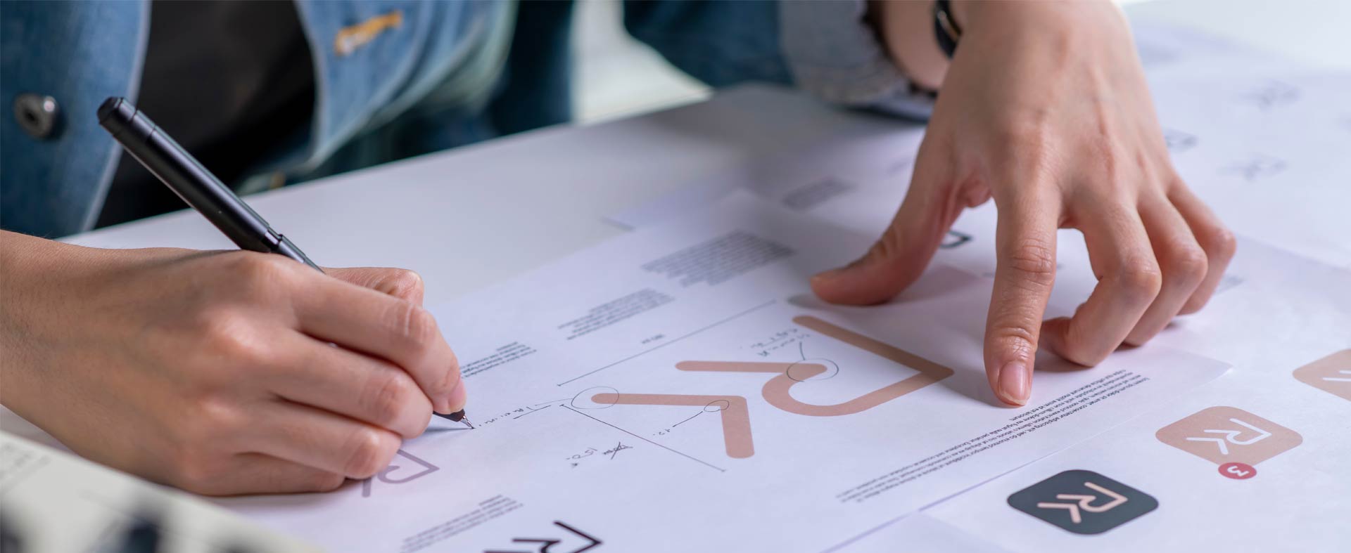 A person refining a logo concept on paper