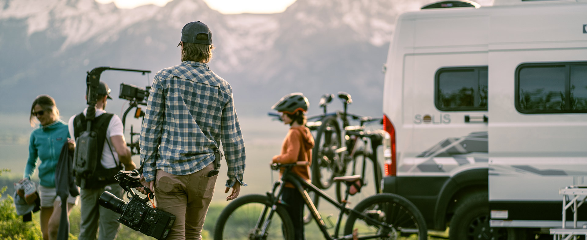 Photo of video location shoot for our Winnebago client: scenic mountain background with camera crew and Solis RV in foreground.