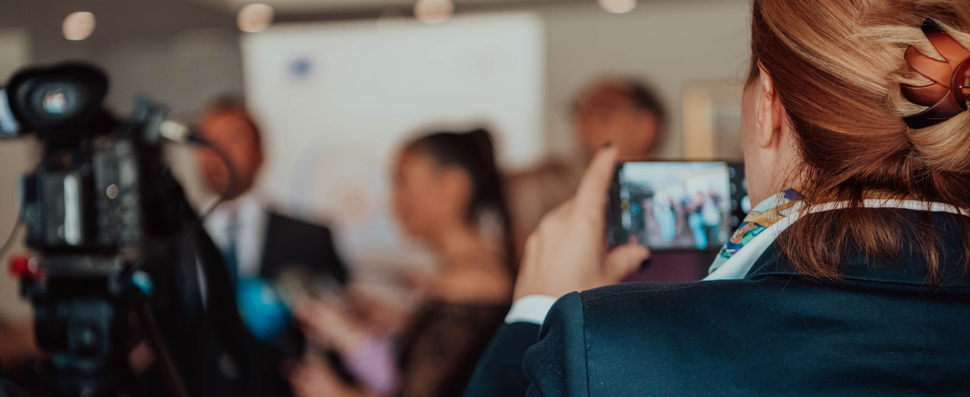 A person recording video of an interview on her phone