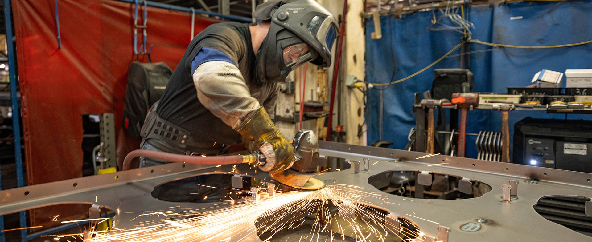 Man grinding metal in a factory
